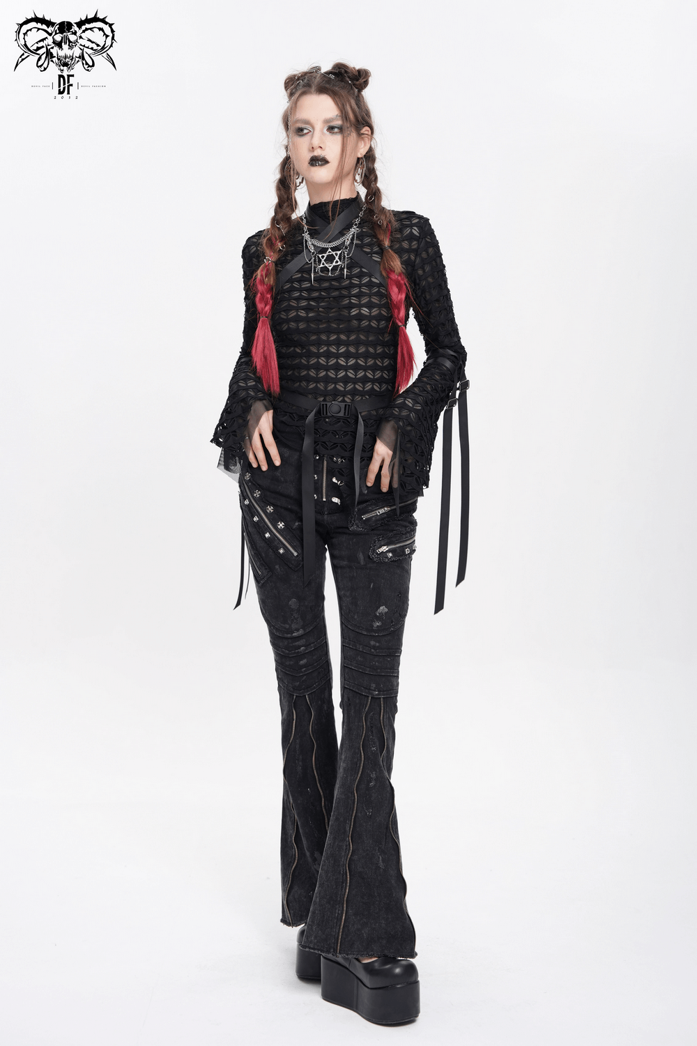 Edgy model in black flared jeans with chains and buckles, styled with gothic top and platform boots.