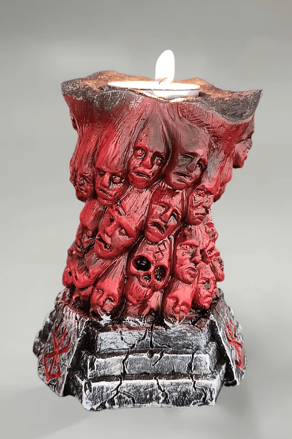 Horror Skull Tealight Holder for Gothic Decor featuring a sinister red candlestick with carved faces.