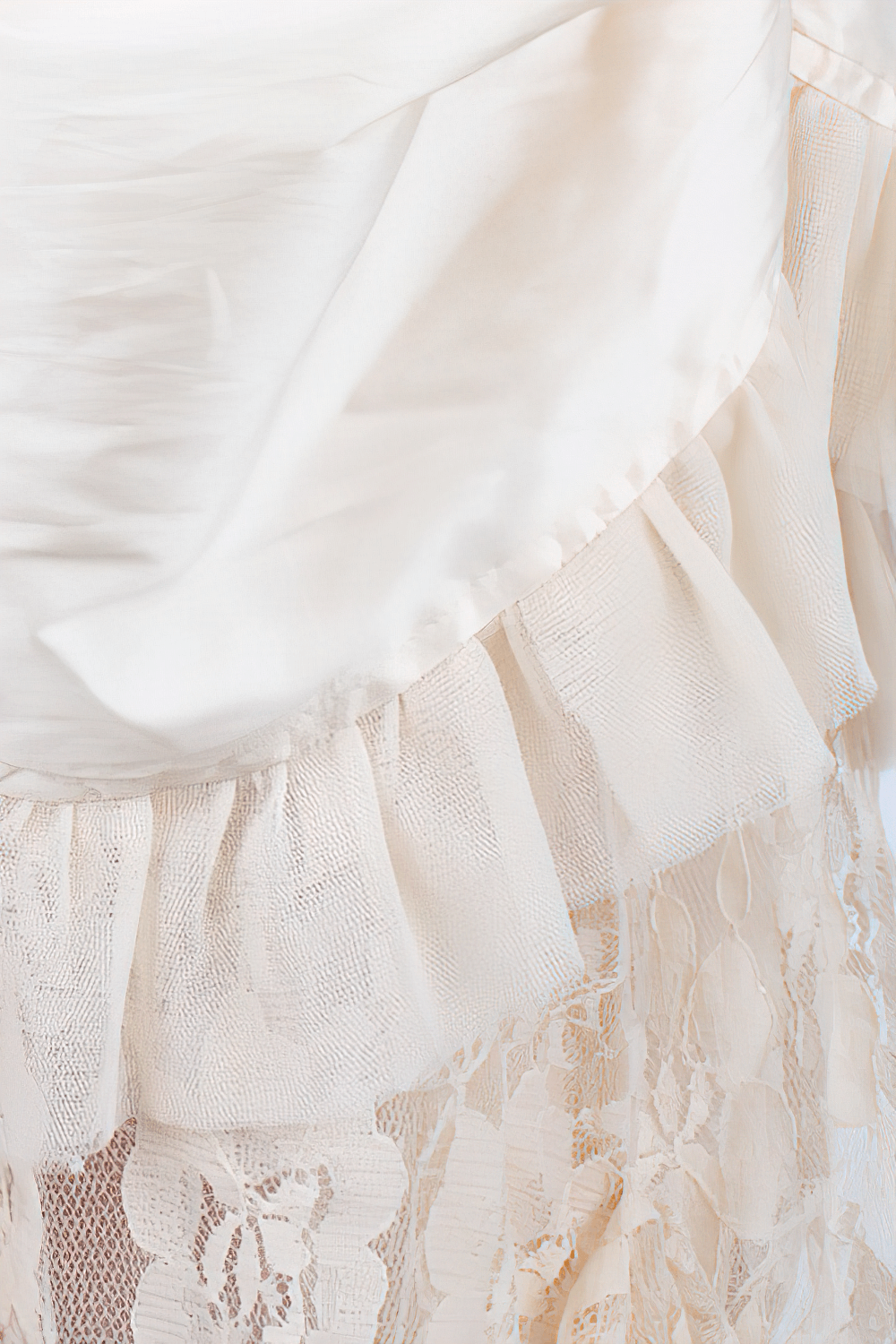 Ivory Victorian bustle skirt detail with soft lace and taffeta layers, showcasing vintage elegance and intricate design.