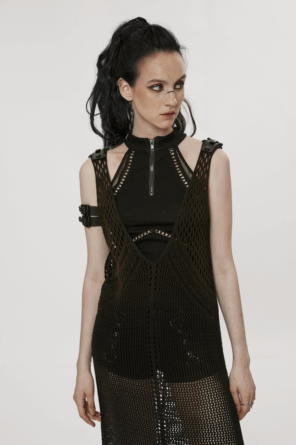 Model wearing a knitted hollow techwear dress showcasing a bold post-apocalyptic style and edgy design.