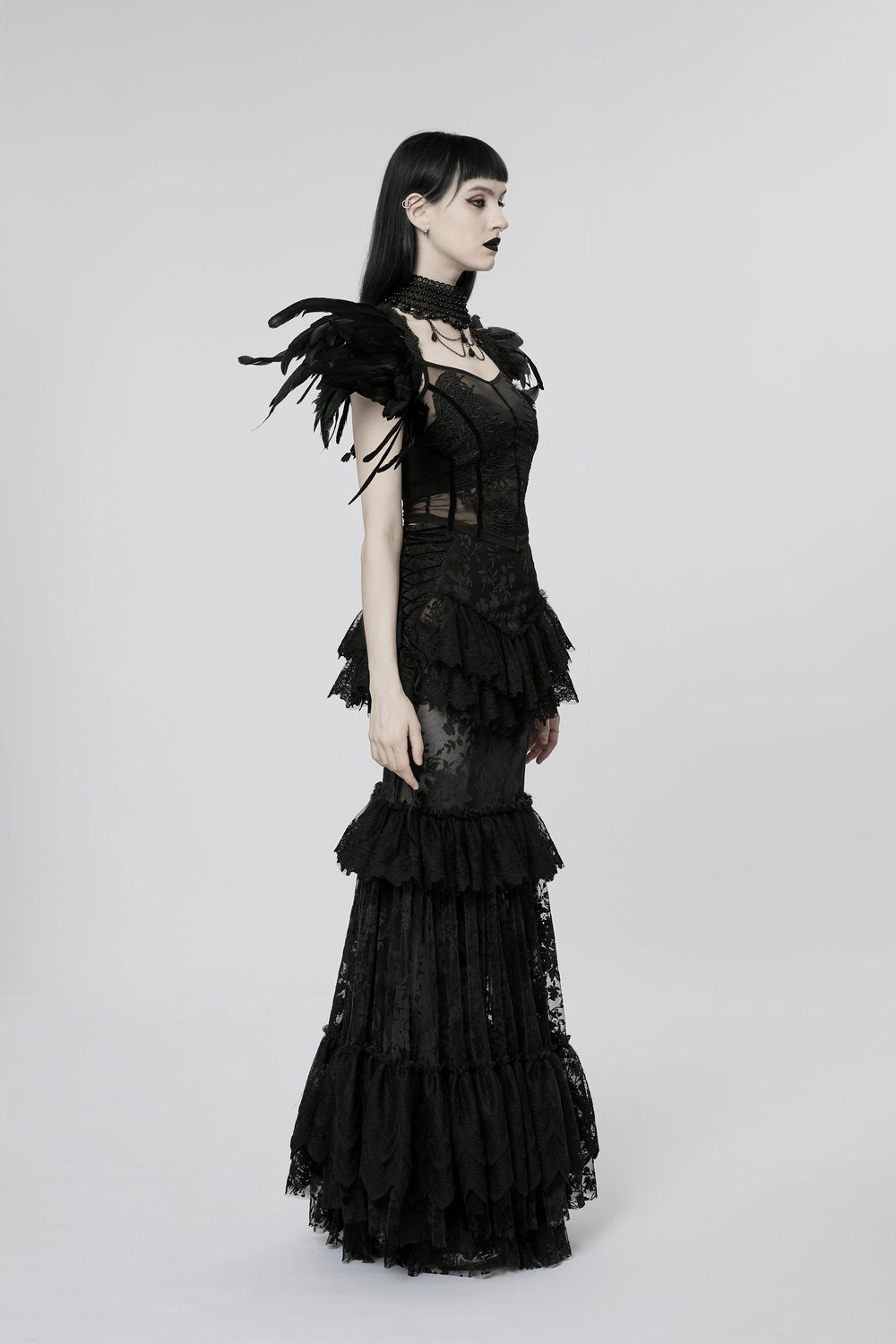 Elegant model in a gothic lace-trimmed full-length skirt showcasing a dramatic layered design and feathered details.