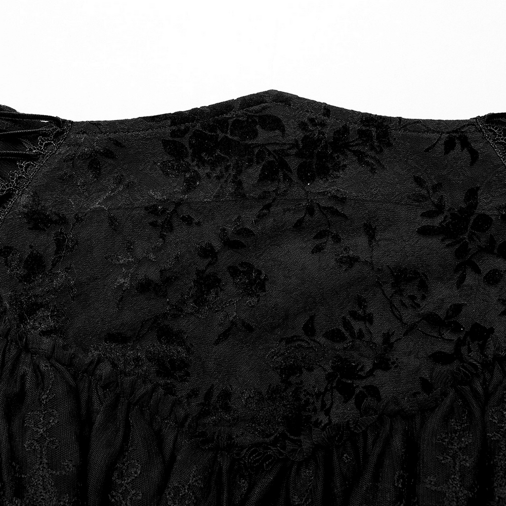 Close-up of intricate lace detailing on a gothic black skirt, showcasing a floral flocking pattern.
