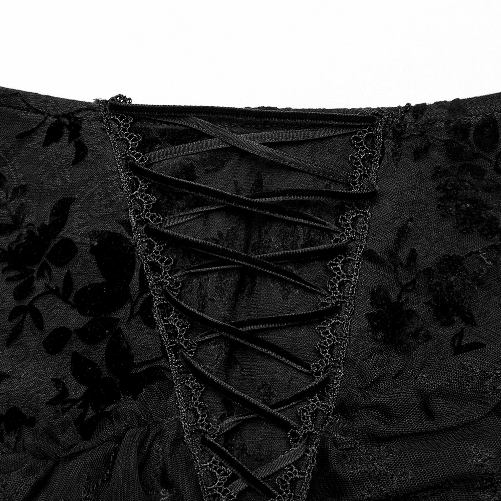 Close-up of gothic lace detailing and corset-style lacing on black transparent skirt fabric.