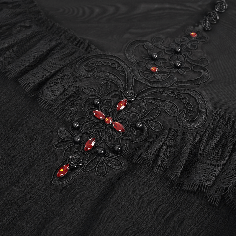 Close-up of the intricate black lace applique and red beaded design on a gothic women's blouse.