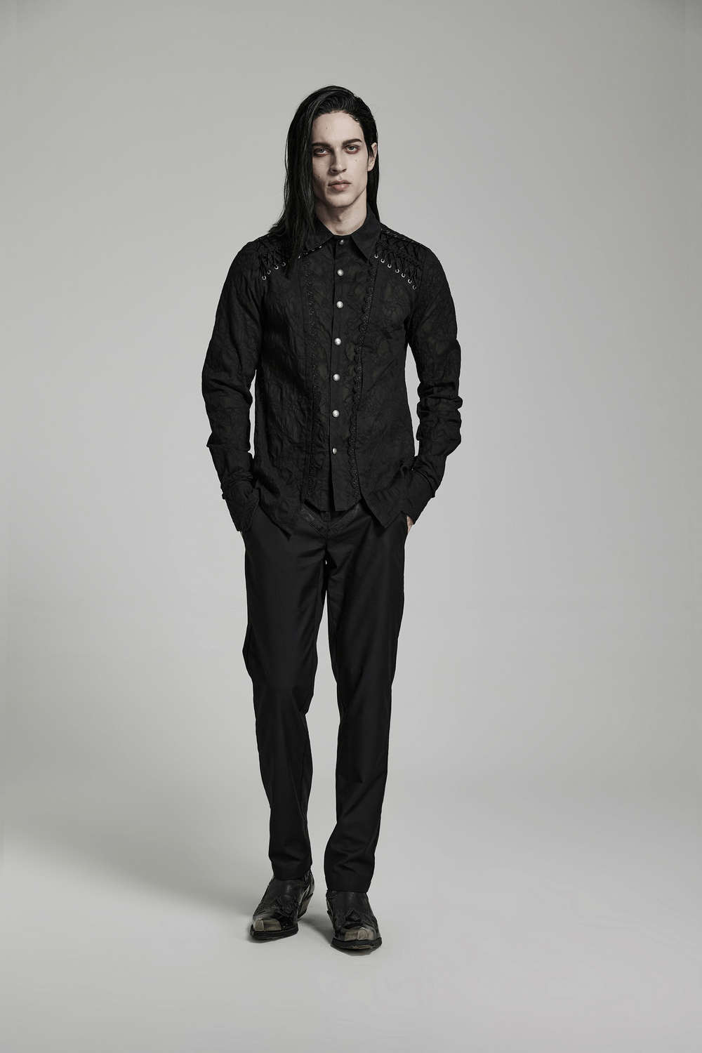 Model wearing a lace-detailed gothic button-up tailored shirt with black pants for a sophisticated gothic look.