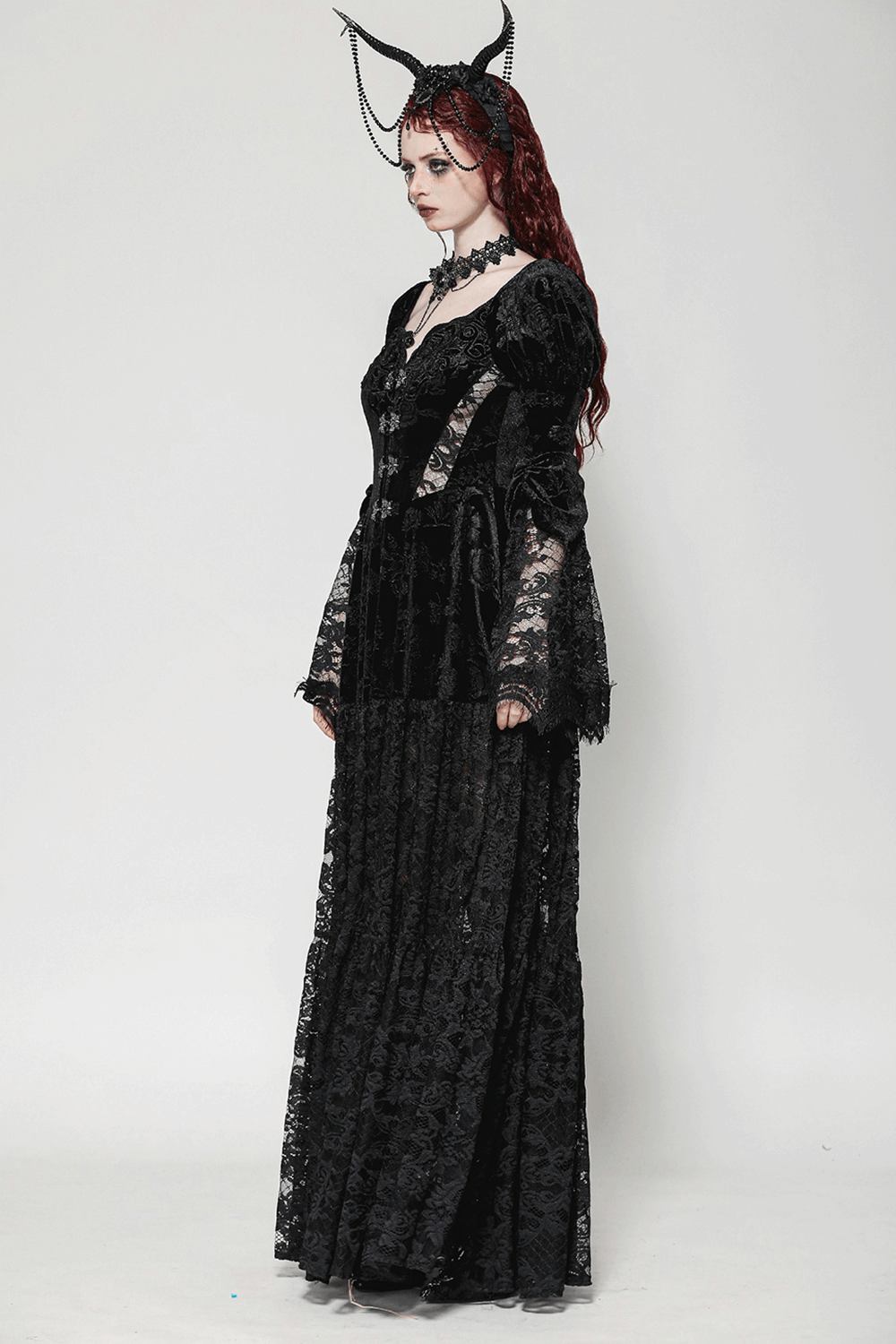 Model wearing a stunning black lace Gothic evening cape dress with floral accents and long sleeves.