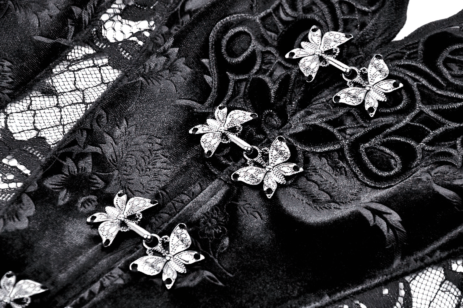 Intricate black lace with floral patterns and butterfly embellishments, showcasing Victorian elegance for evening wear.