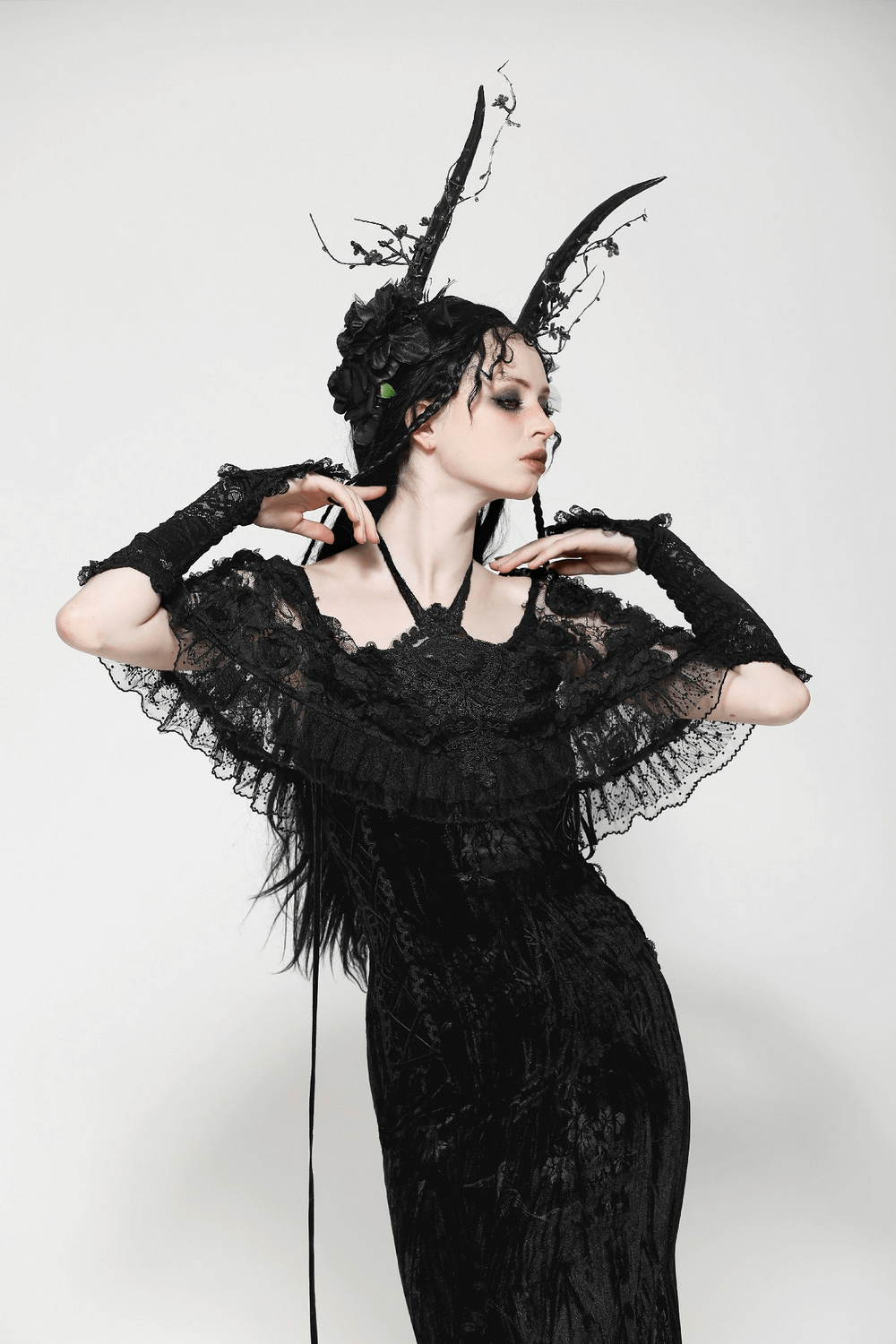 Model showcasing black lace long fingerless gloves with frills, paired with an elegant gothic dress and dramatic headpiece.