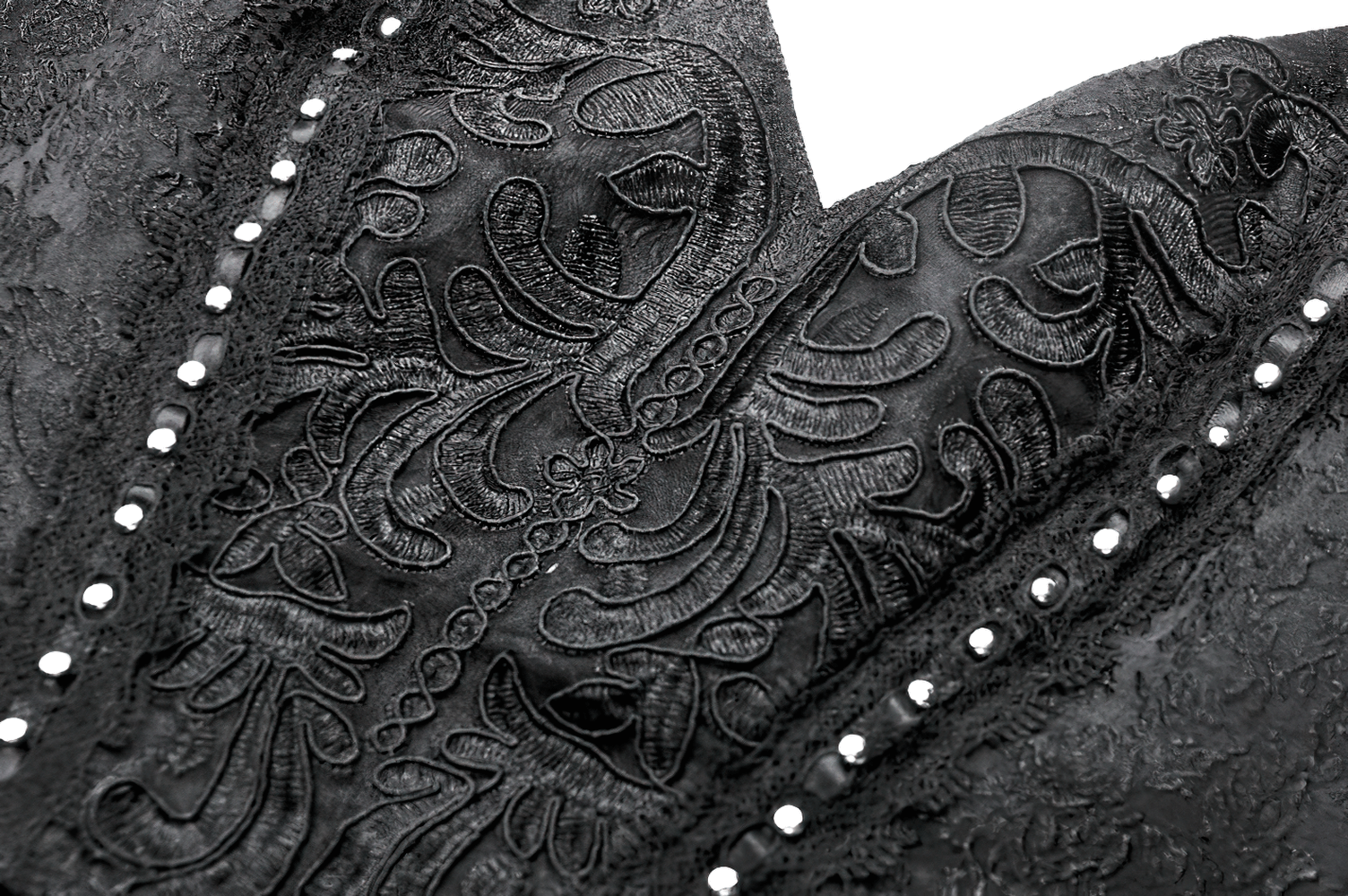 Close-up of intricate black lace detailing on a halter corset dress, showcasing elegant floral patterns and decorative studs.