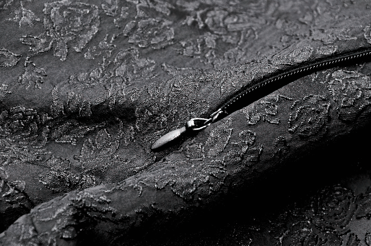 Close-up of luxurious lace fabric with floral pattern and zipper detail, perfect for a chic corset dress.