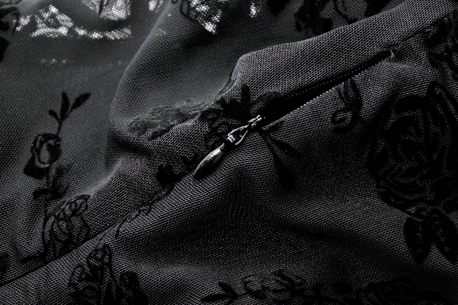 Close-up of the dark floral design and zipper detail on the Lace Mini Dress with Bell Sleeves and Back Lace-up Design.