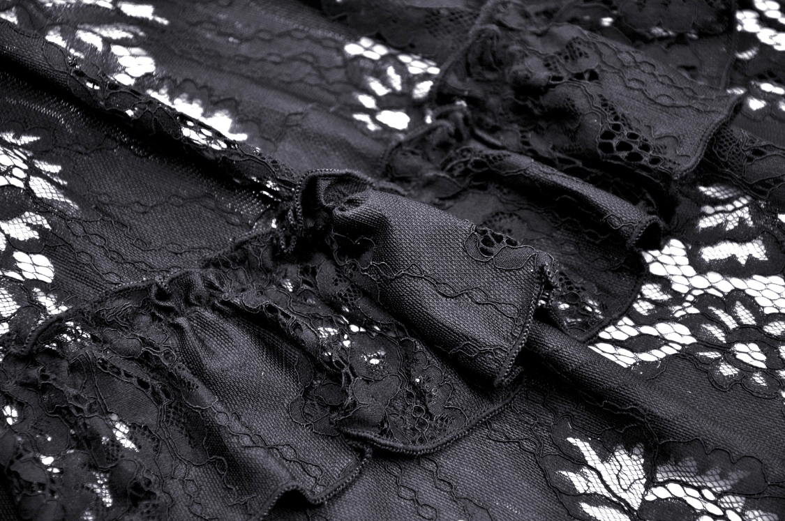 Close-up of intricate black lace featuring ruffled detailing, perfect for a gothic off-shoulder dress.