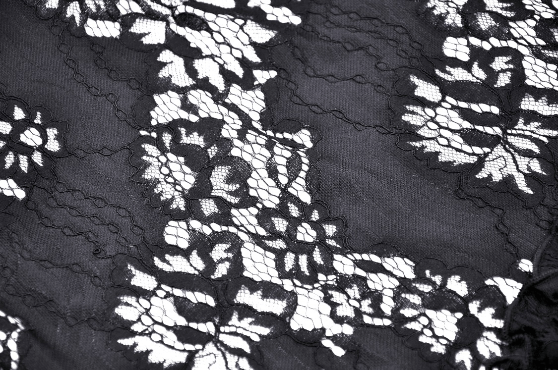 Close-up of intricate black lace fabric with floral patterns, perfect for gothic fashion and dark romantic styles.