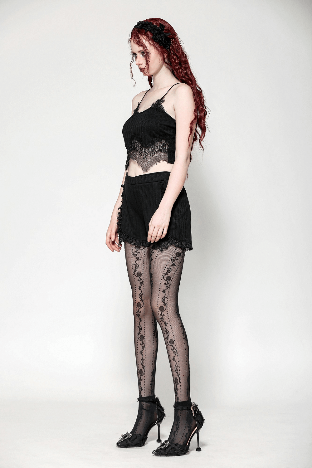 Elegant black high-waist lace trim shorts paired with a delicate matching top and lace-patterned tights.