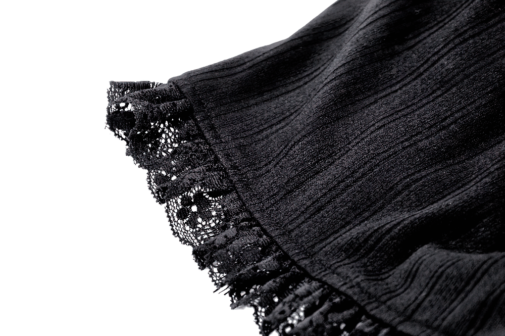 Close-up of black lace trim on ruffled shorts showcasing vintage pinstripe design and elegant texture.