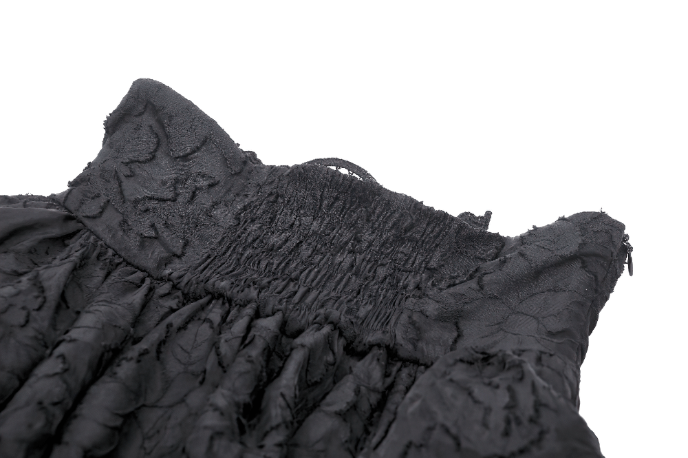 Close-up of the smocked neckline and detailed texture of a black Victorian inspired skirt.