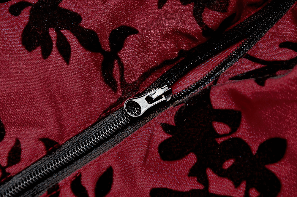 Close-up of a zipper on a lace-trimmed satin corset top with floral pattern in rich burgundy.