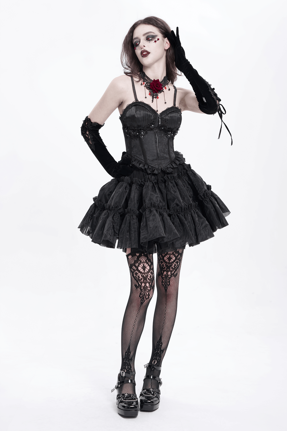 Gothic style model in black lace corset and ruffled skirt with floral accents and accessories, exuding elegance and bold fashion.