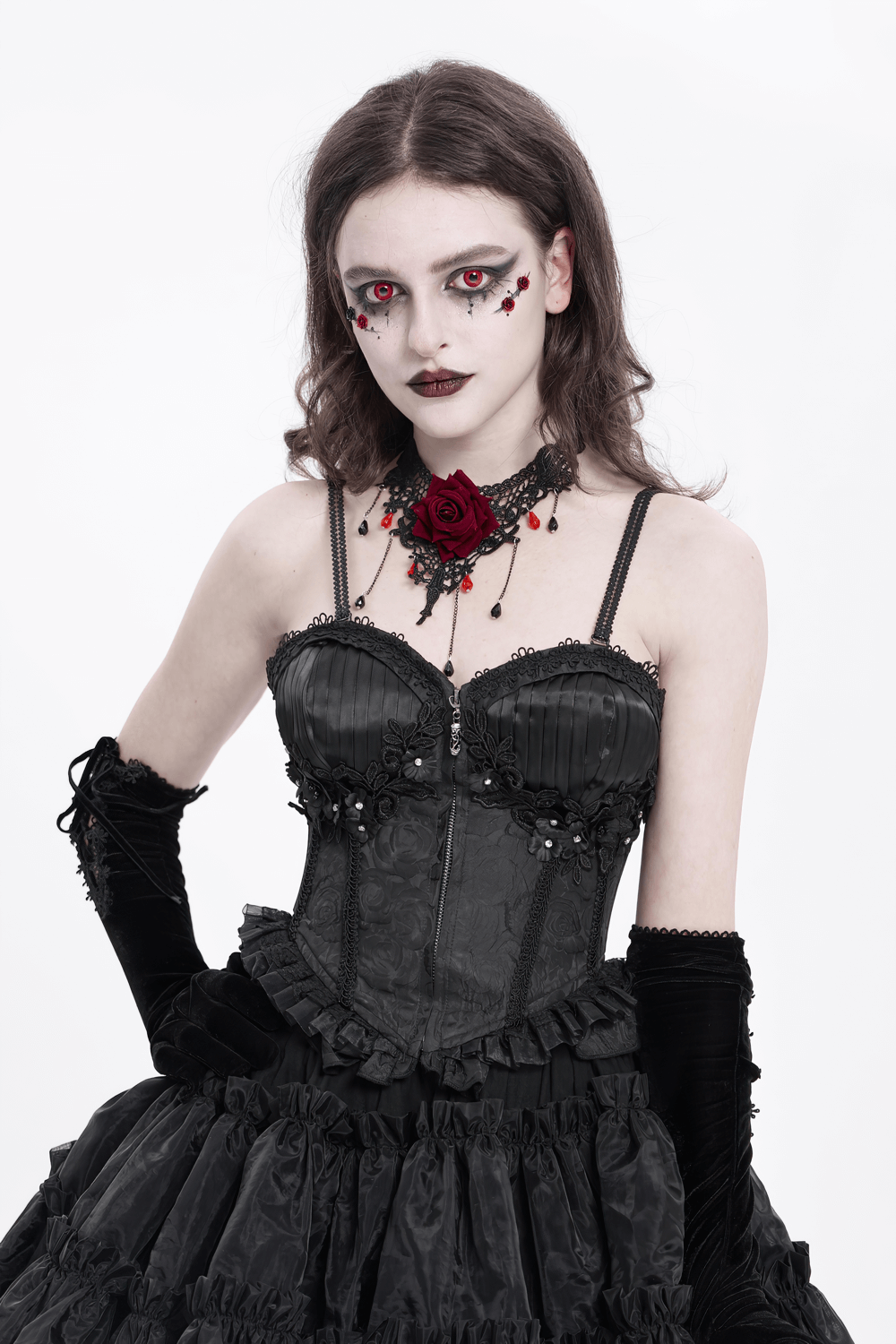 Model wearing a black floral embellished corset with ruffle detail, showcasing gothic elegance and dramatic makeup.