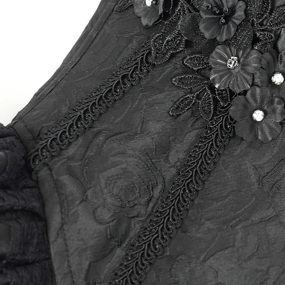Close-up of a black floral corset showcasing intricate lace details and embellishments.