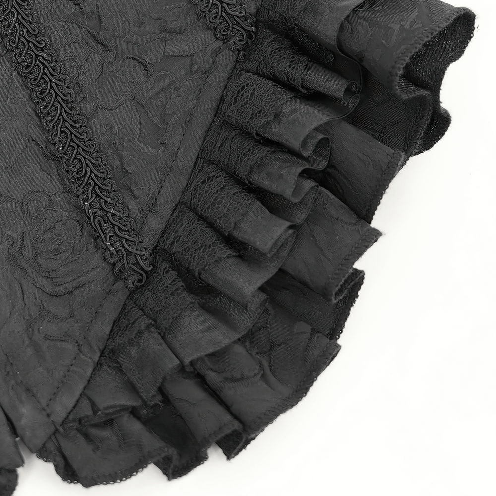 Close-up of ruffled black floral lace fabric detail, showcasing elegant texture and embellishments.