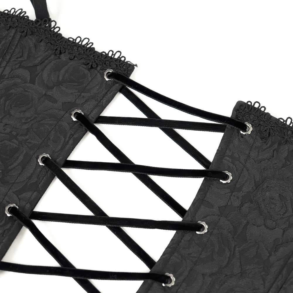 Close-up of black lace-up corset with floral pattern and ruffle edge detail, showcasing elegant style.