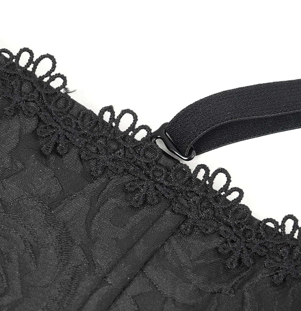 Close-up of black floral lace detail on corset with elegant ruffle trim and adjustable strap.