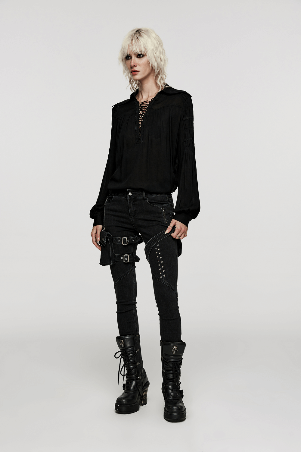Gothic blouse with pleated sleeves, lace-up detail, styled with edgy black jeans and boots.
