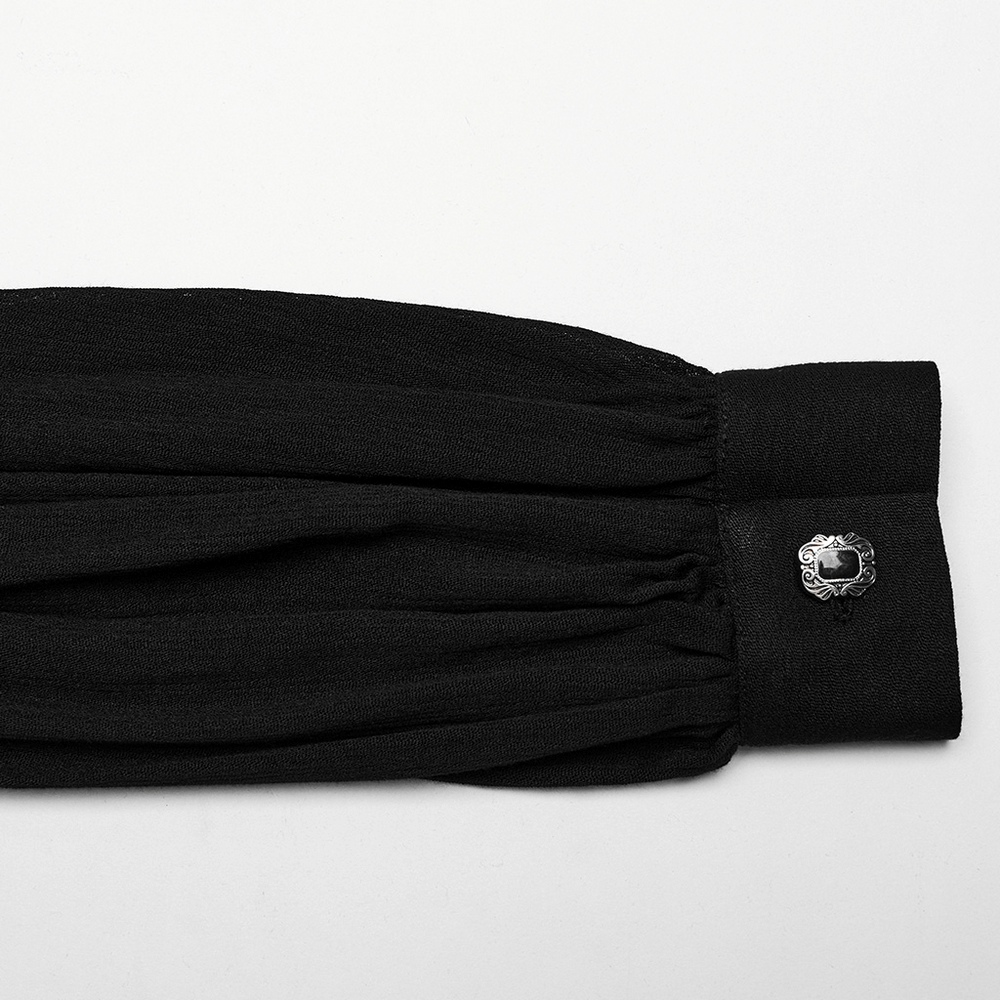 Close-up of pleated sleeve cuff with ornate button detailing on a black gothic blouse.