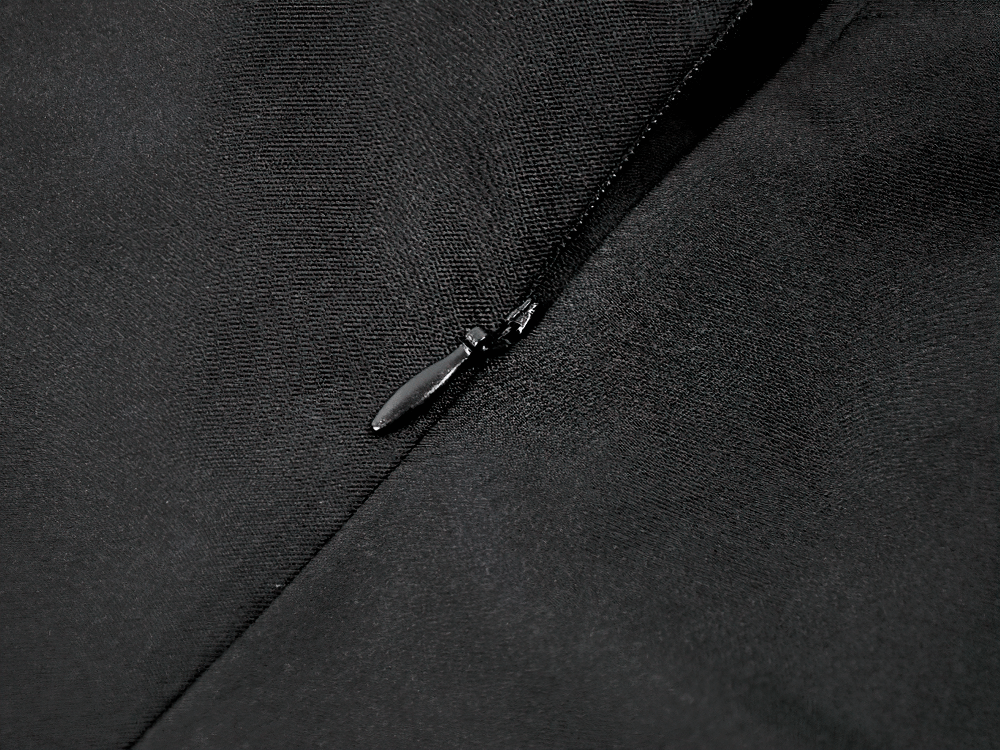 Close-up of zipper detail on Lace-Up Gothic Dress with Puff Sleeves and Ruffled Hem, showcasing smooth black fabric.