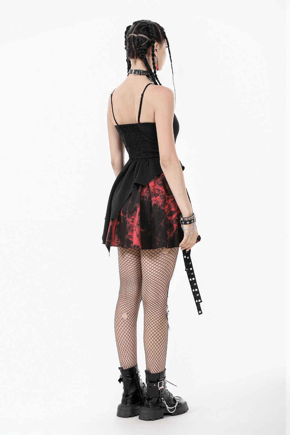 Back view of a black lace-up mini dress with red tie-dye hem, paired with fishnet tights and punk-inspired accessories.