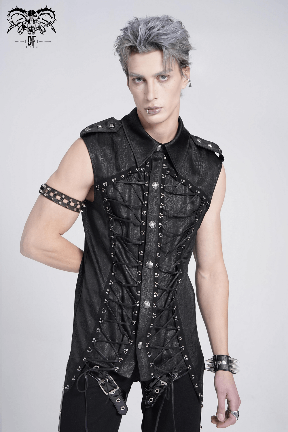 Lace-up sleeveless shirt with epaulets and metal buttons, stylishly worn by a model with gray hair.