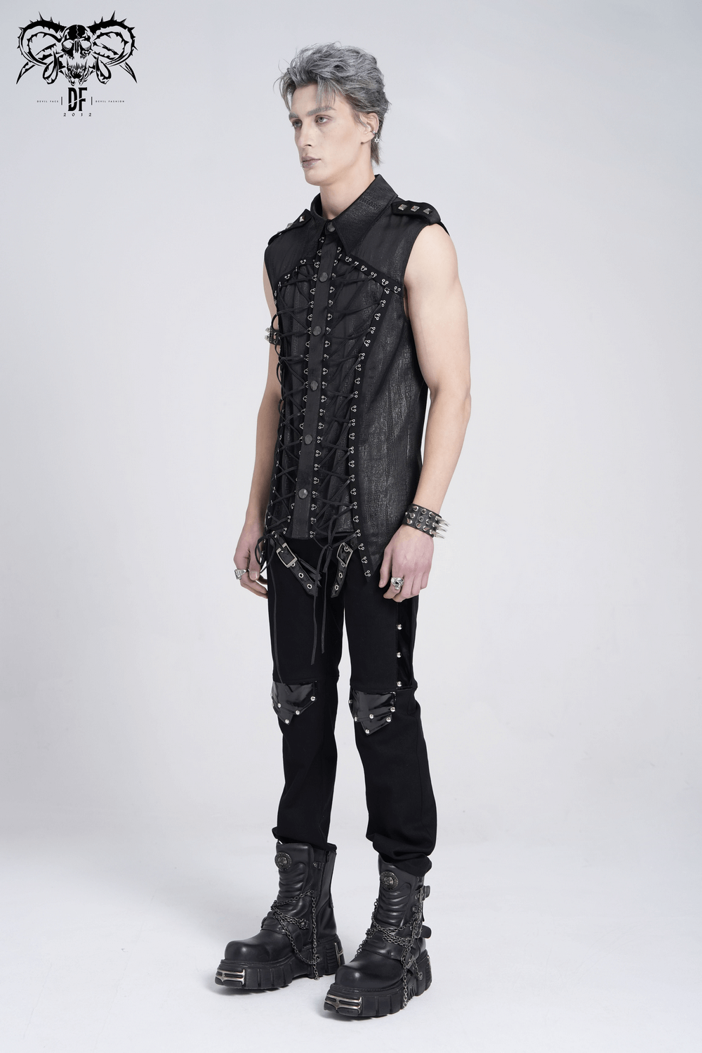Stylish lace-up sleeveless shirt with epaulets and metal buttons, worn by a model in edgy black pants and boots.
