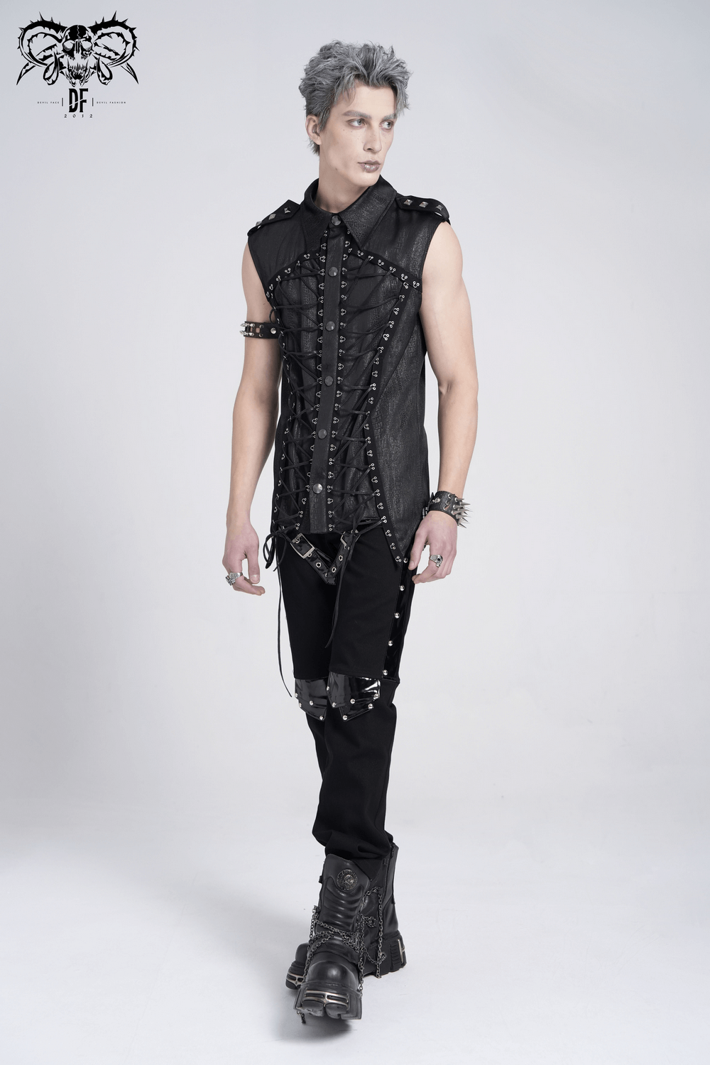 Lace-up sleeveless shirt with epaulets and metal buttons, styled with edgy black pants and boots.