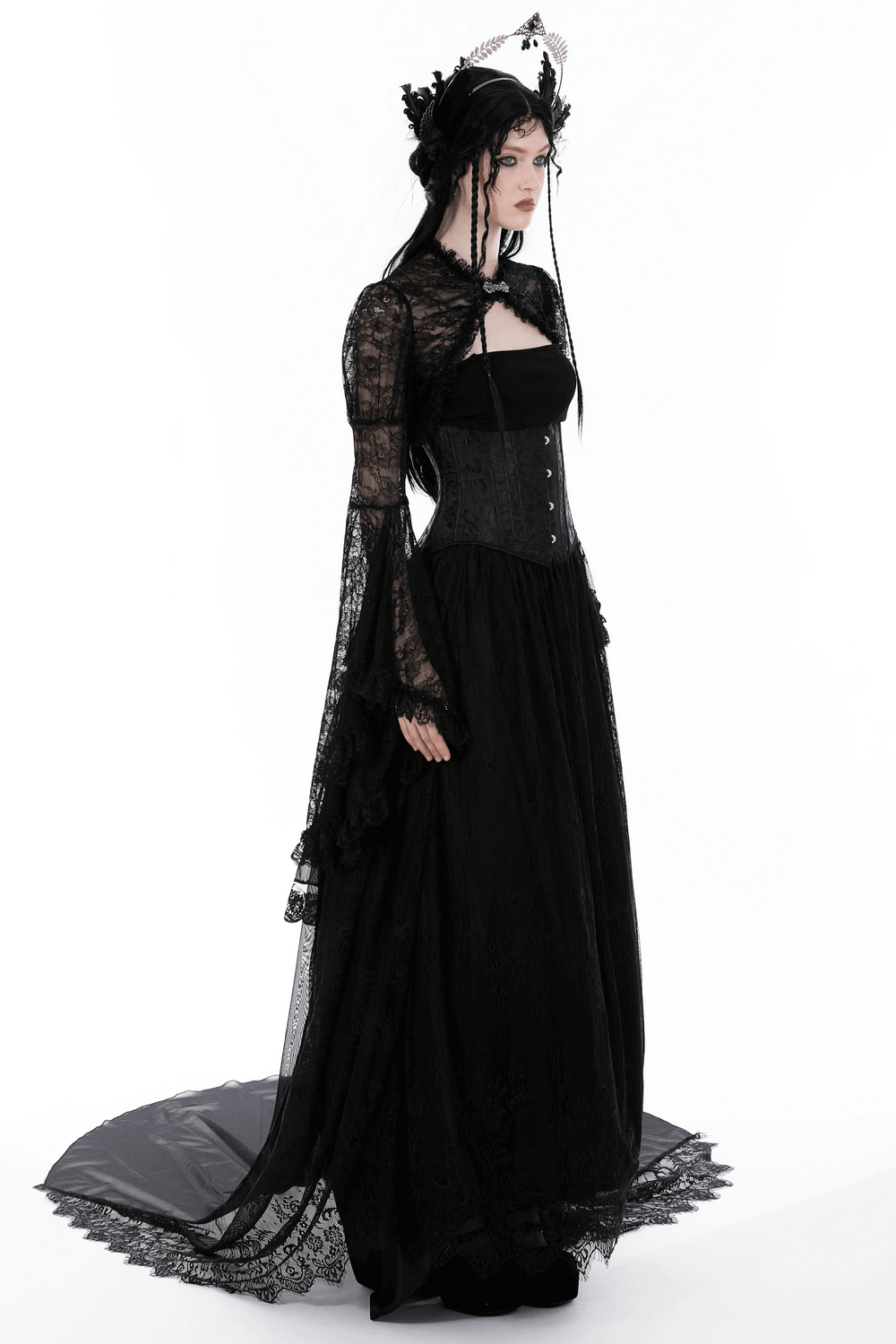 Elegant Gothic model in black lace bolero shrug with long sleeves, paired with a dramatic corset and flowing dress.