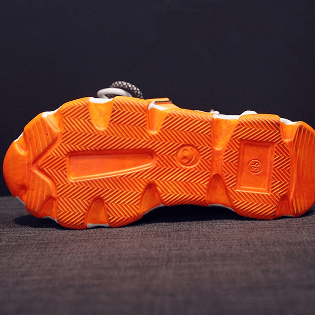 Underside view of ladies chunky platform sandals featuring a vibrant orange rubber sole.
