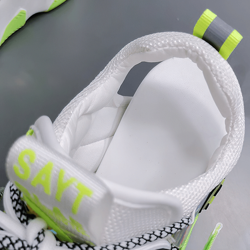 Inside view of a white sneaker with neon accents, featuring a cushioned insole and sleek design for comfort.