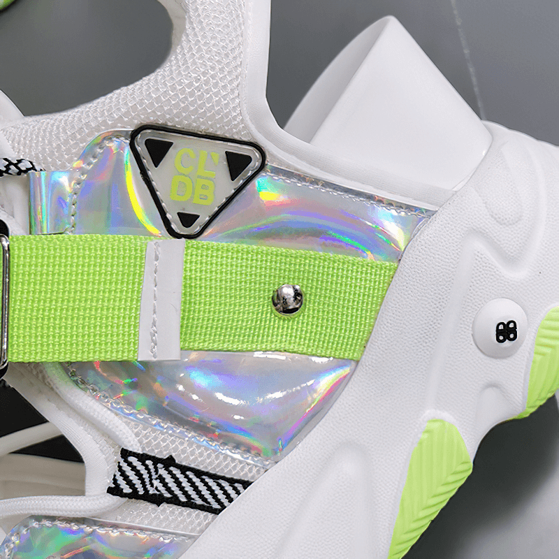 Close-up of ladies chunky platform sandals showing shiny materials and neon buckle strap design.