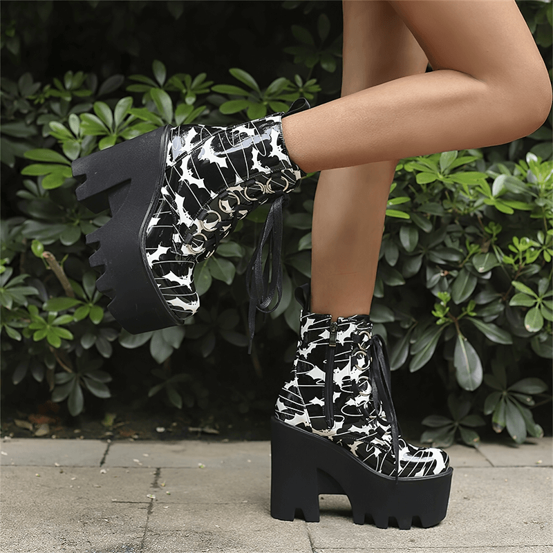 Stylish ladies goth platform ankle boots with bat print, featuring thick black heels and lace-up design.