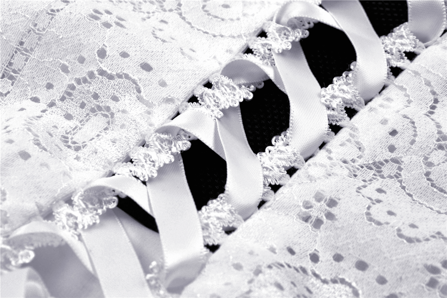 Close-up of intricate lace and satin ribbon details on a stylish white midi dress, highlighting gothic elements.
