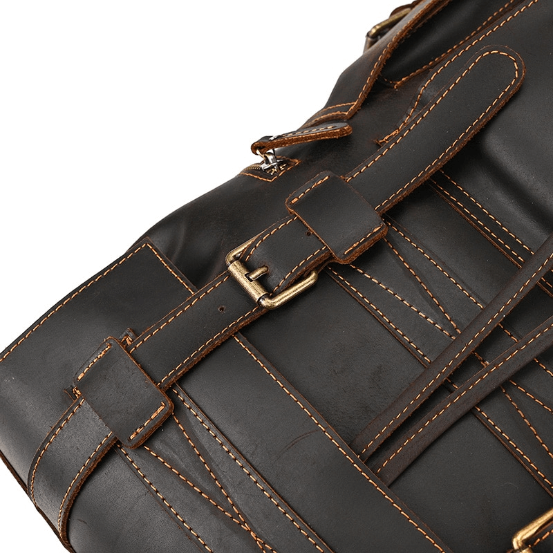 Close-up of buckled straps on a large genuine leather backpack, highlighting its stylish design and quality craftsmanship.