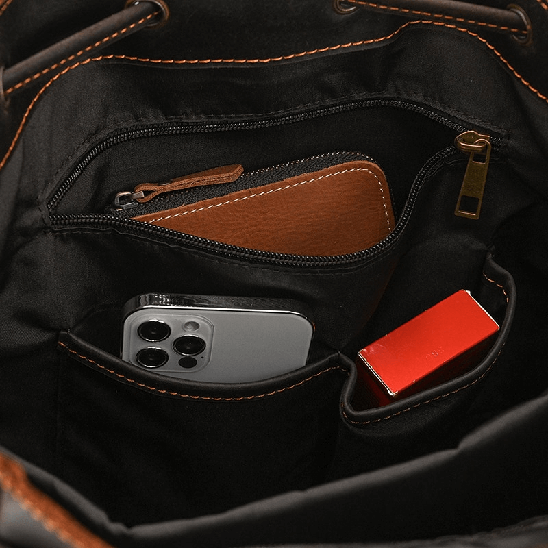 Interior pockets of a genuine leather backpack showcasing wallet, phone, and essentials organized neatly