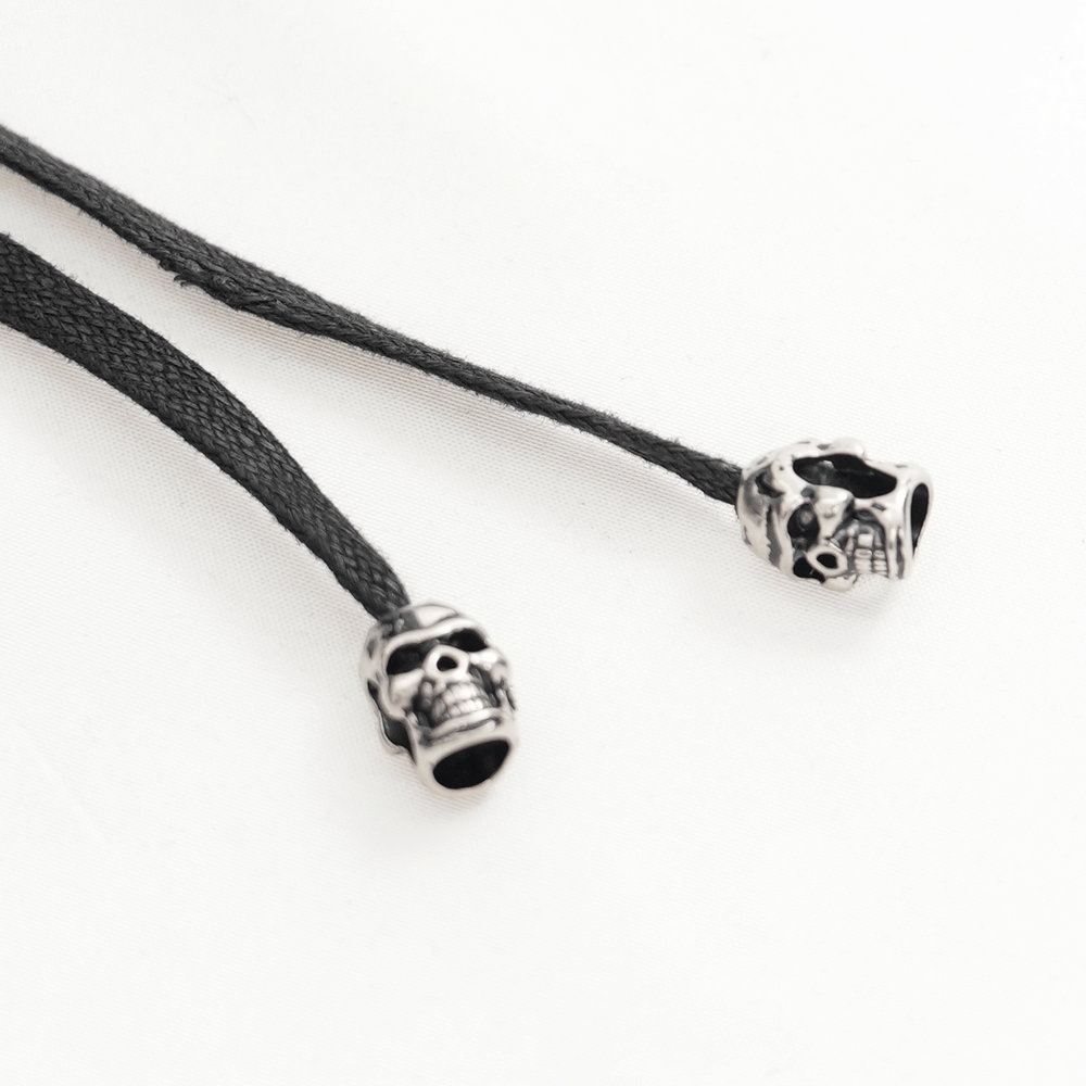 Skull bead details on black shoelaces for a gothic and edgy style accessory. Perfect for alternative fashion lovers.