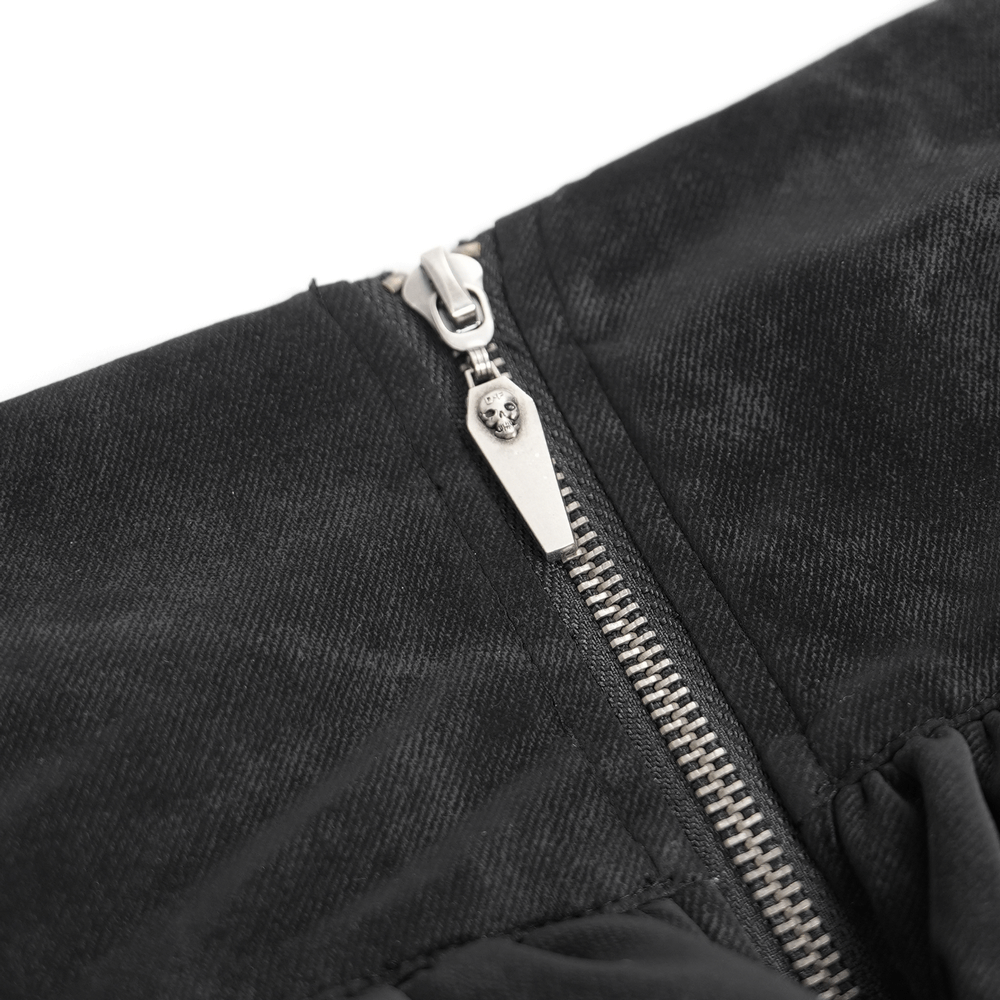 Close-up of zipper detail on a gothic skirt, featuring a silver skull pull and textured black fabric.