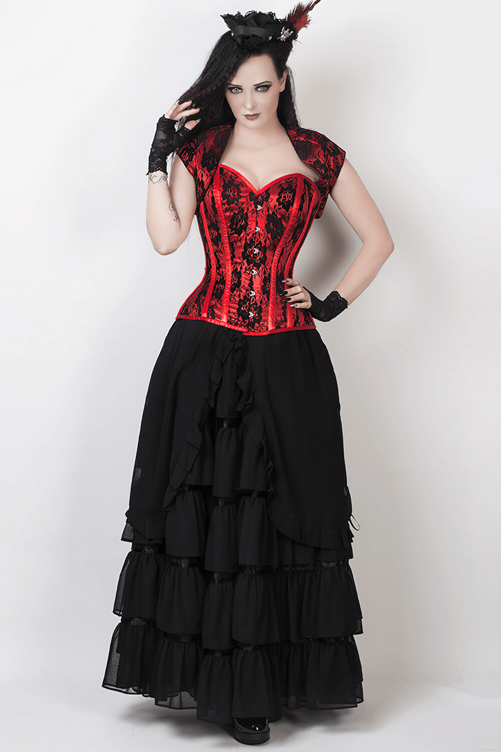 Elegant model in layered black Victorian maxi skirt and red corset for striking evening style.