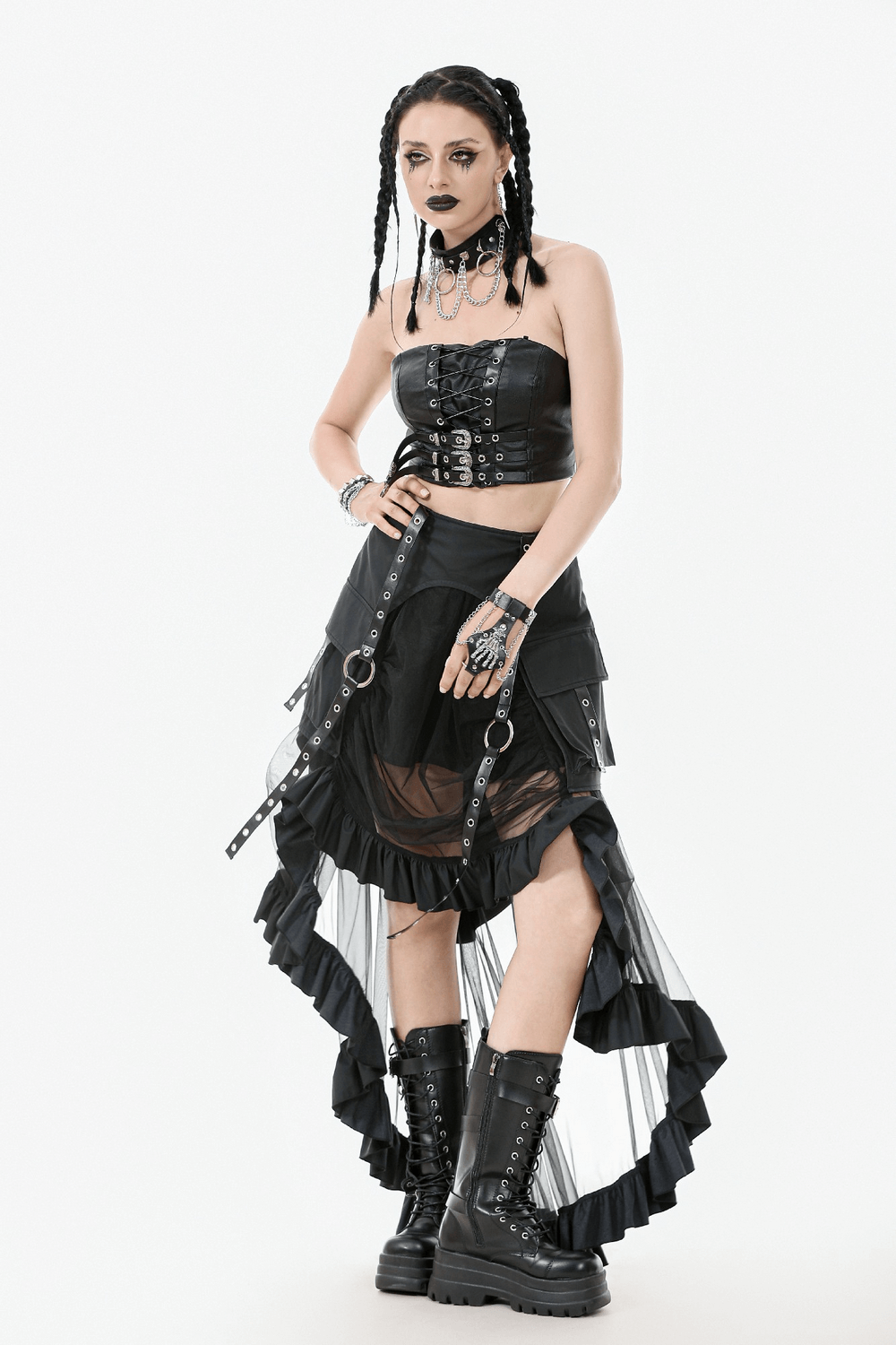Woman in a black layered mesh high-low ruffle skirt with straps and buckles, showcasing a punk gothic style.