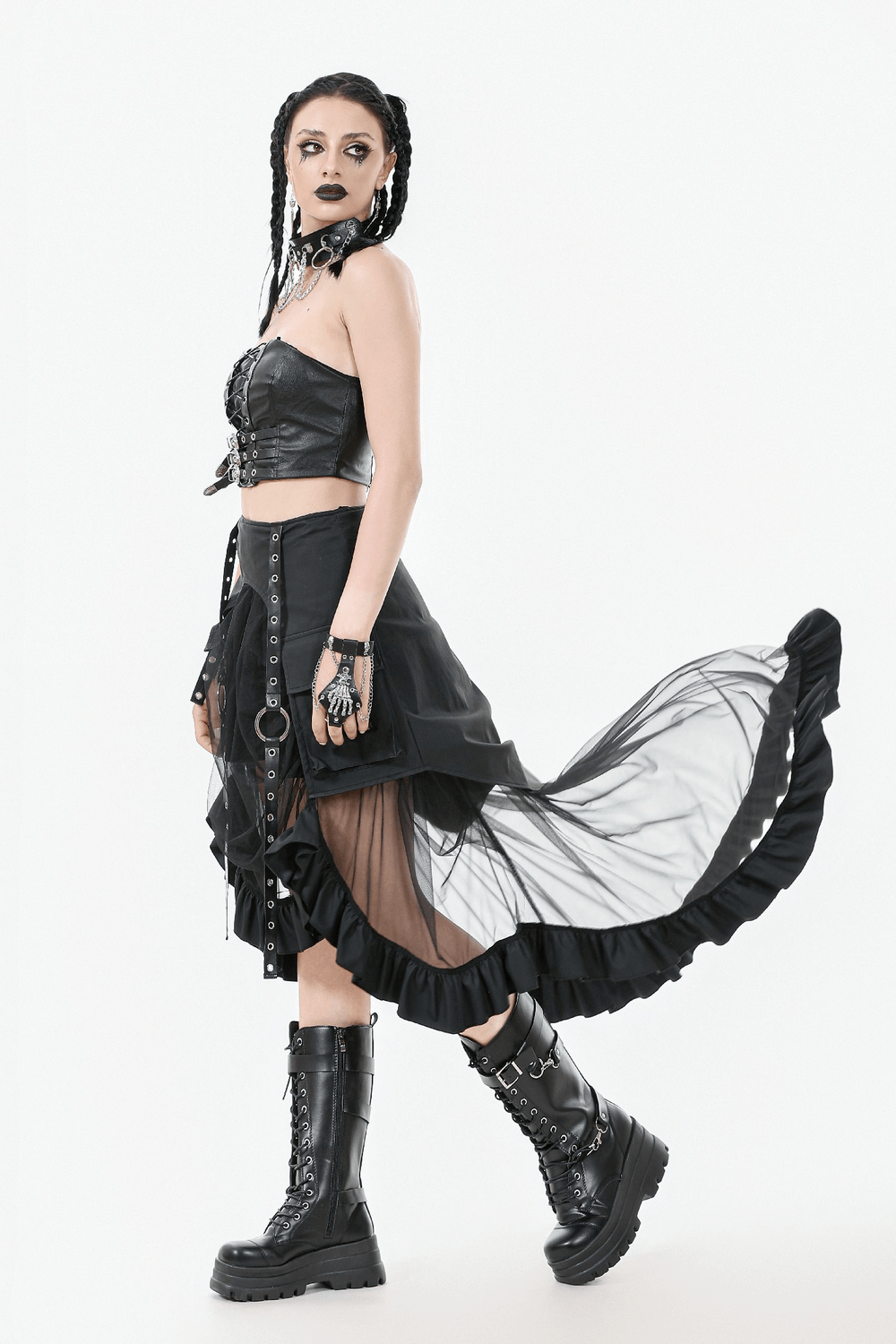 Gothic woman in layered mesh high-low ruffle skirt, black corset, and chunky boots, exuding punk style and attitude.