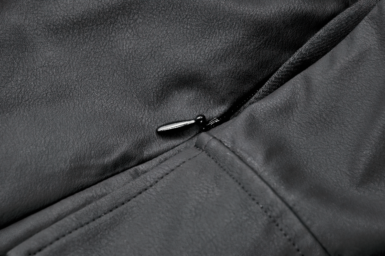 Close-up of a sleek black leather jacket zipper detail, showcasing modern design and craftsmanship.