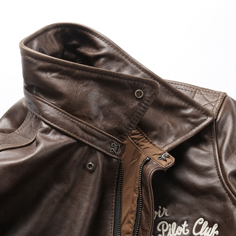 Close-up of a brown leather biker jacket showing a stylish collar and embroidered patches for a rock look.