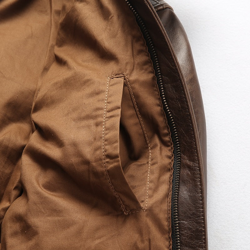 Interior view of a brown leather biker jacket showcasing its smooth lining and pocket design.